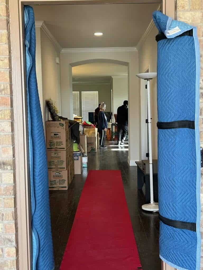 Front doorway protected with padded door jambs and a red floor runner before an Elite Star move
