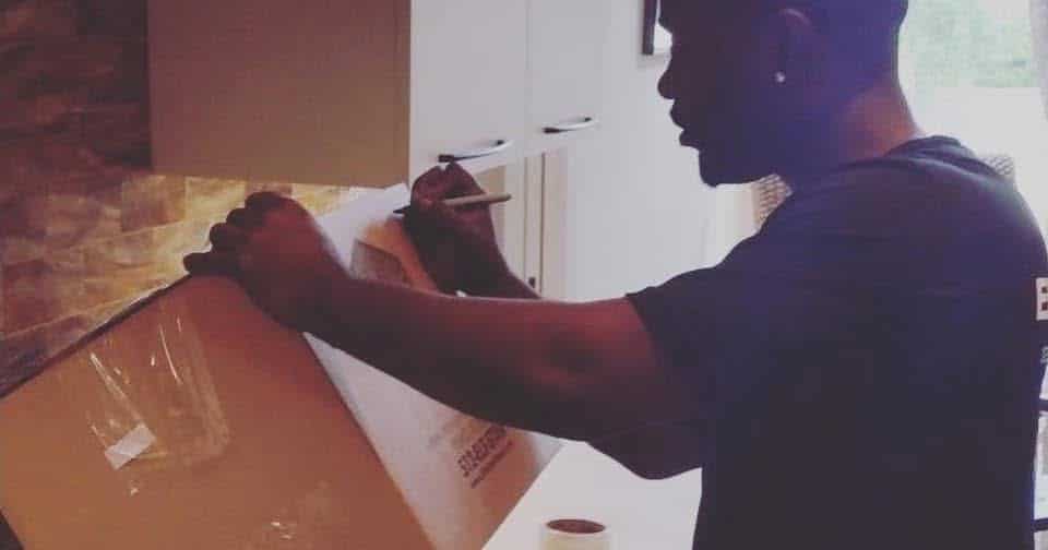 Elite Star Movers crew member labeling a packed box in a kitchen